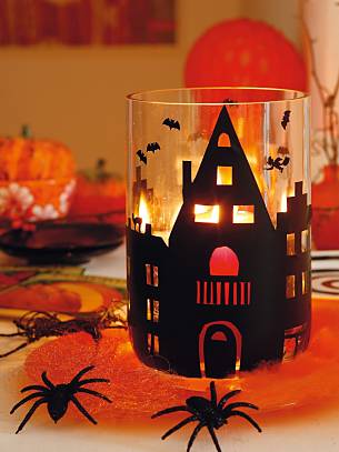 Verschieden große Häuser in Schwarz aus selbstklebender Folie oder Pappe auf einer Glasvase. Für Kerzenlicht (am schönsten orangefarben), sorgen eingeschnittene Fenster und Türen.