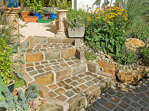 Natursteine können auch in einem Mörtel- oder Betonbett verlegt werden, zum Beispiel beim Bau von Stufen.
