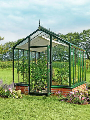 Das Gewächshaus Bio-Top (www.hoklartherm.de) ist für kleine Gärten geeignet. Hier ein Modell mit Zierelementen, Innenschattierung und aufgemauertem Sockel
