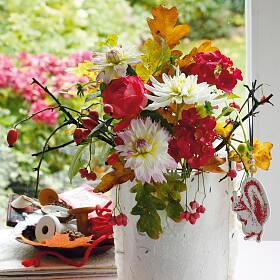 Eine Husse aus stabilem Papier nähen und über ein ­Gurkenglas stülpen. Üppig mit verschiedenen Blumen, Blättern und Zweigen von Pfaffenhütchen füllen.