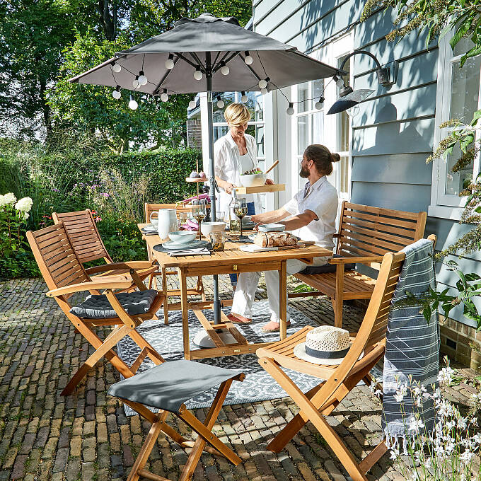 Der Sonnenschirm „Siesta“ von Butlers spendet tagsüber angenehmen Schatten und erhellt abends mit einer Lichterkette den Sitzplatz.